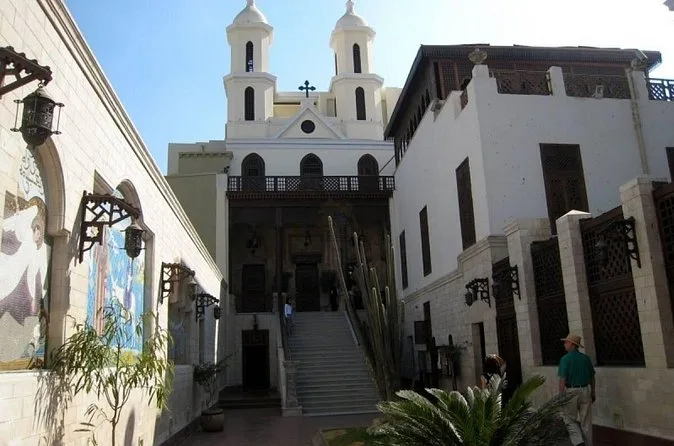 Des marches de pierre menant à l'Église suspendue du Caire copte, avec des tours blanches au-dessus
